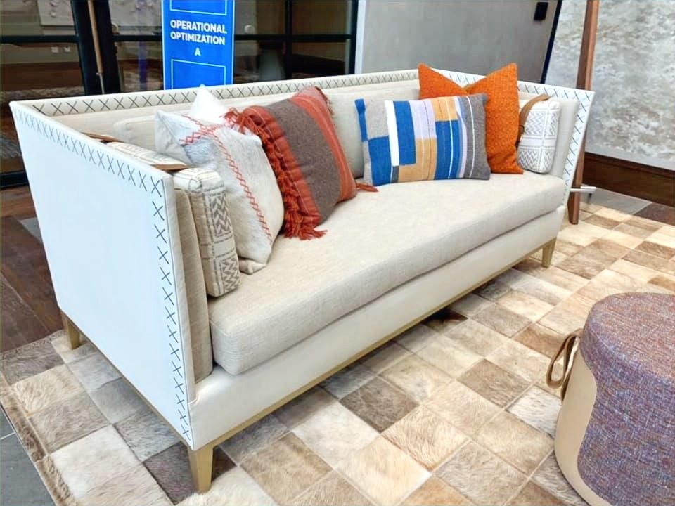 Cream sofa with nailhead trim and colourful pillows