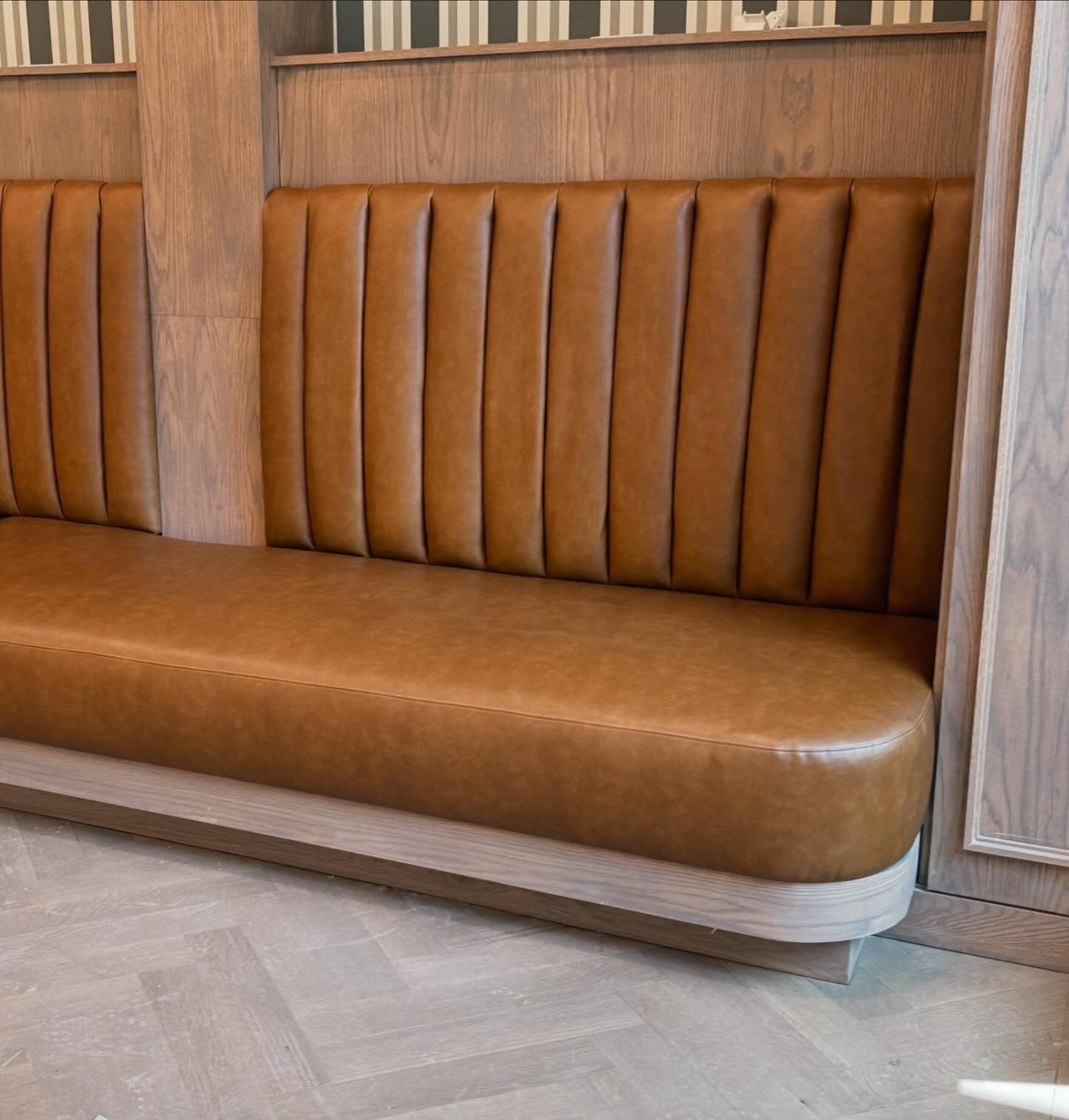 Channel-tufted tan leather restaurant banquette