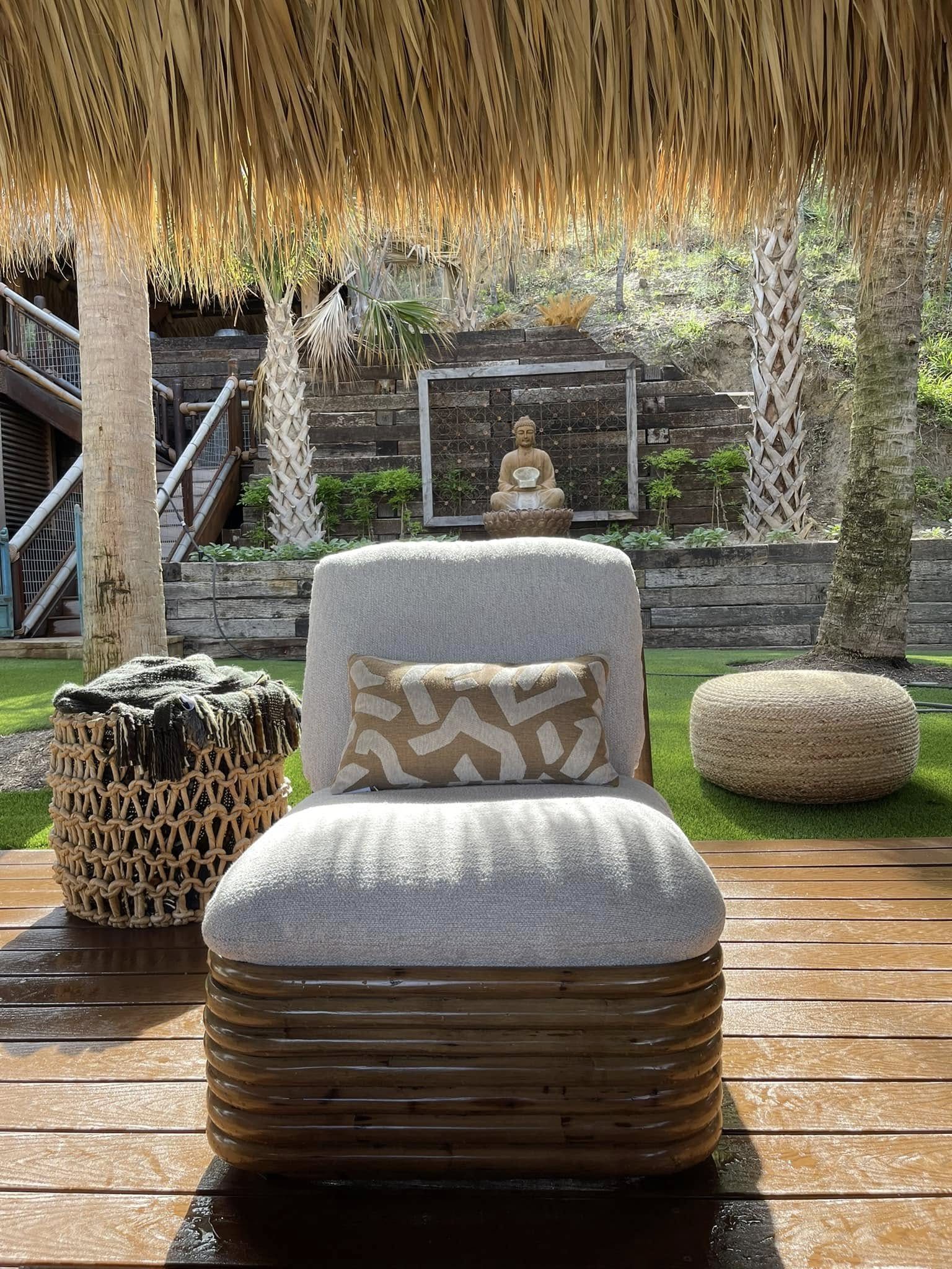 Outdoor lounge chair under a thatched palapa