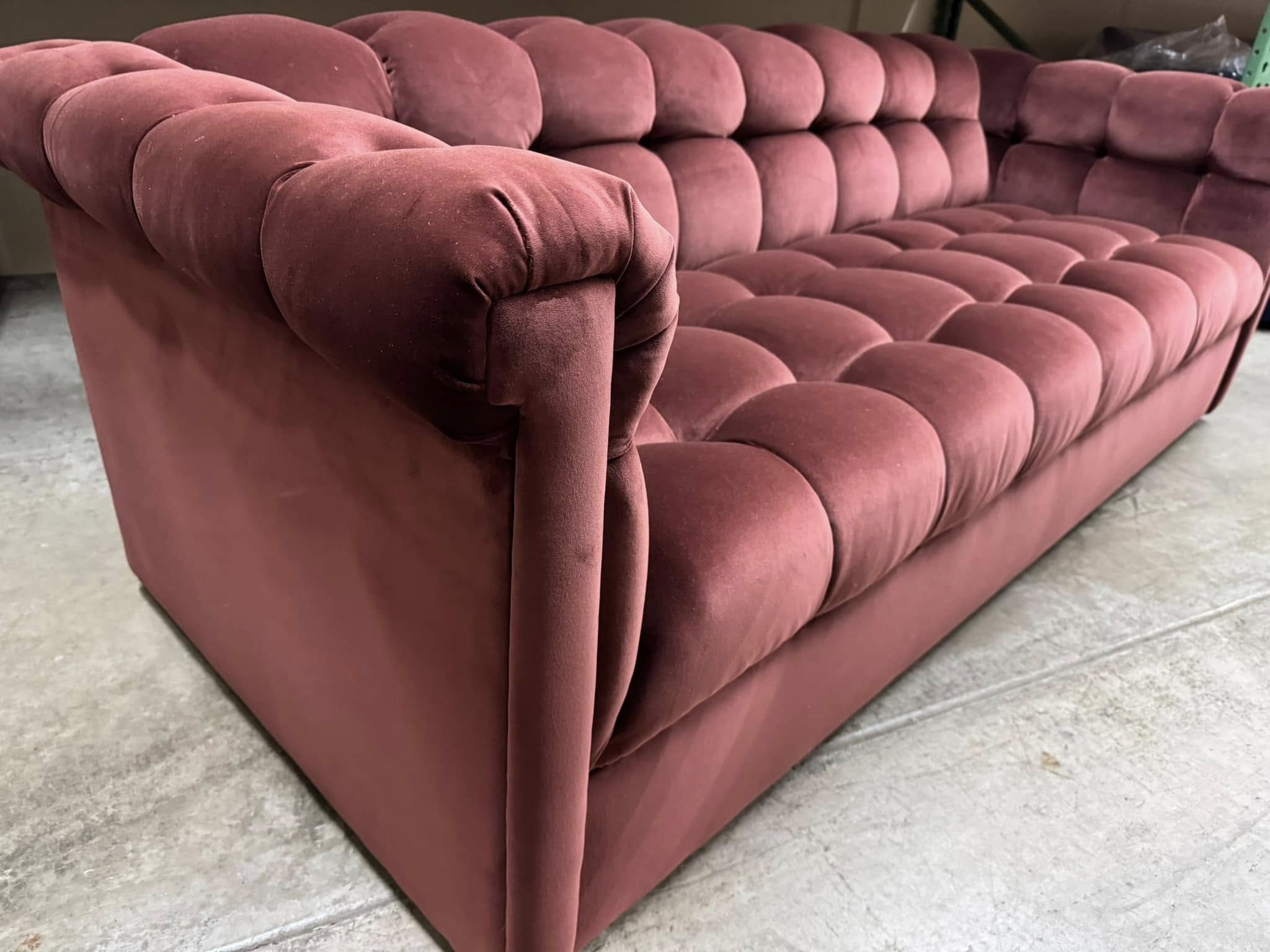 A deep-buttoned chesterfield sofa reupholstered in rose velvet