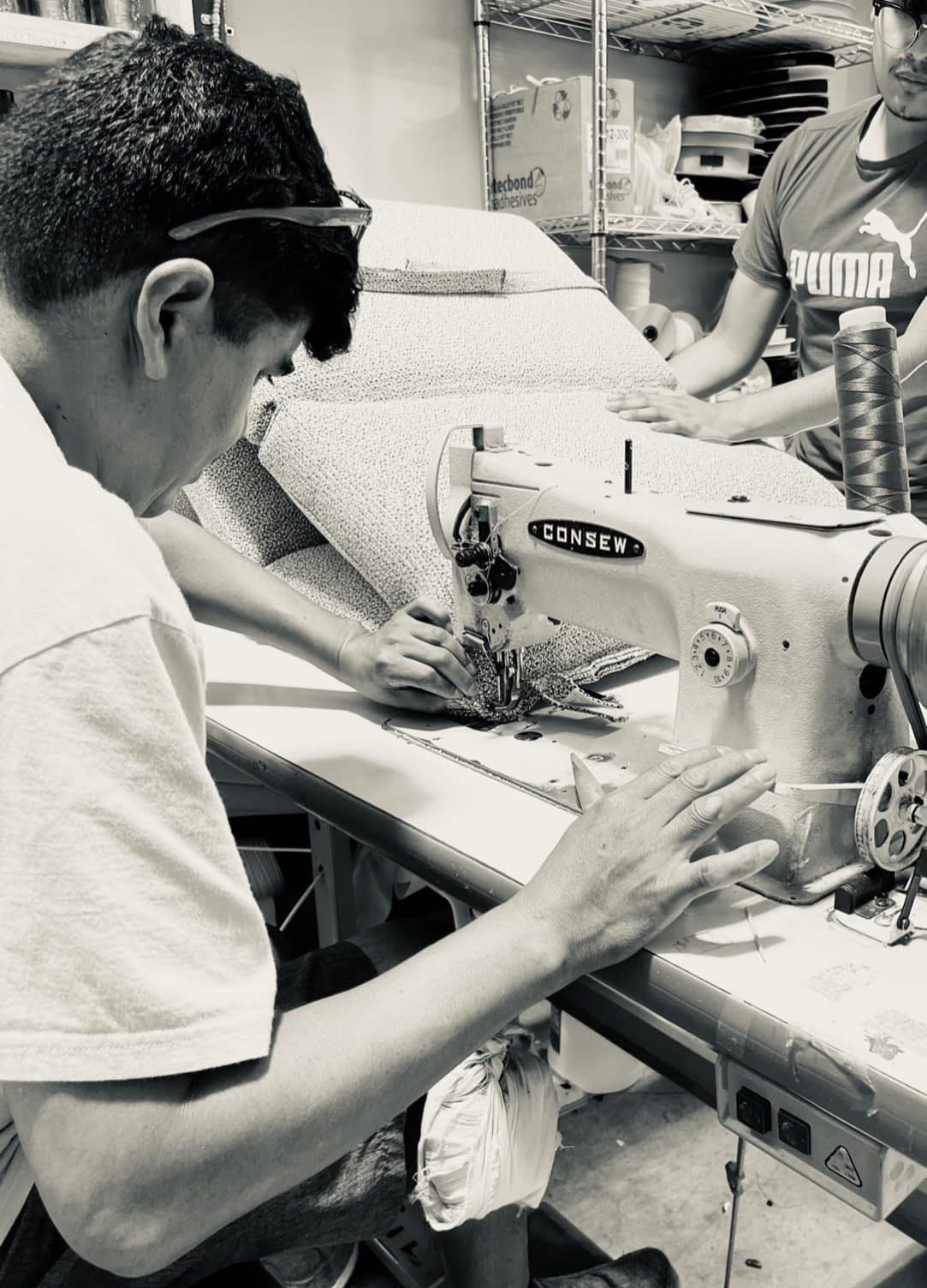 Upholsterer sewing a welted seam on an industrial machine